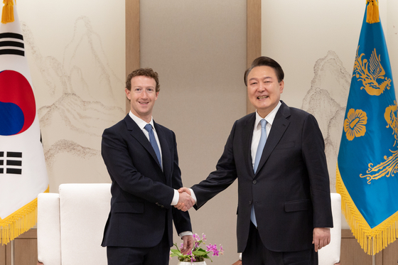 President Yoon Suk Yeol, right, shakes hands with Mark Zuckerberg, the chief executive of Meta, at the Yongsan presidential office in central Seoul on Thursday. [PRESIDENTIAL OFFICE]