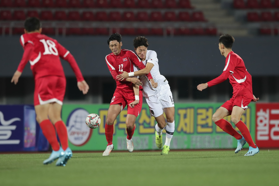 North Korea's Ri Yong-jik, second from left, struggles with South Korea's Hwang Ui-jo in the third Group H match of the second qualifying round for the World Cup at Kim Il-sung Stadium in Pyongyang, North Korea in October 2019. [YONHAP]