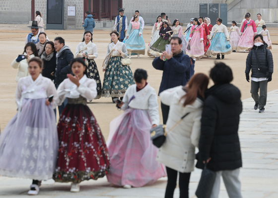 Tourists in hanbok, or Korean traditional dress, visit Gyeongbok Palace in Jongno District, central Seoul, on Sunday afternoon. [YONHAP] 