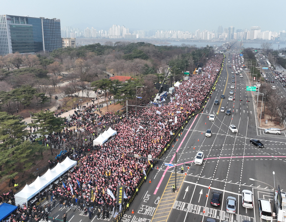 Participants at a rally opposed to the government's plan to expand the country's medical school admissions quota by 2,000 spots next year crowd a street near Yeouido Park in western Seoul on Sunday afternoon. [YONHAP]