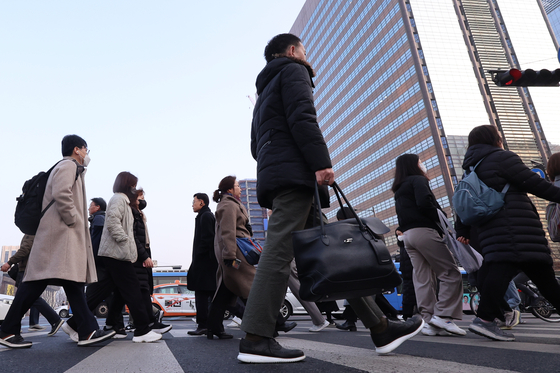 Citizens cross the crosswalk at Gwanghwamun Square in central Seoul during their morning commute. [YONHAP]