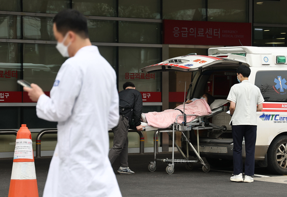 A doctor passes an emergency room at a hospital in Seoul on Tuesday. The government on the same day said it would go forward with administrative procedures against some 7,000 trainee doctors who have still not returned to work. [YONHAP]