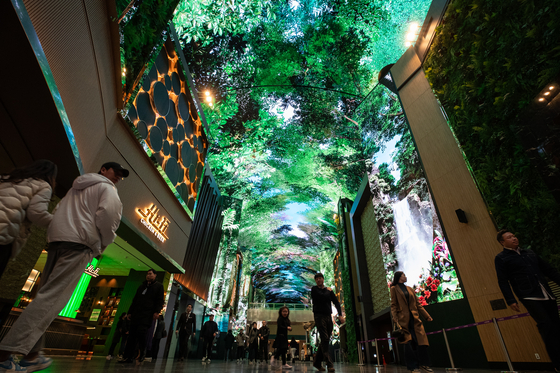 People walk along “Aurora,” a state-of-the-art digital entertainment street featuring large LED screens at Mohegan Inspire Entertainment Resort in Incheon, on Tuesday. [NEWS1]