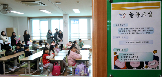 Students and parents listen to an orientation session explaining the Neulbom School child care program at Seobu Elementary School in Daejeon on Tuesday with the start of a new school semester. Starting this semester, first graders can recieve before and after school care services from 7 a.m. to 8 p.m. in 2,741 elementary schools nationwide. [NEWS1]