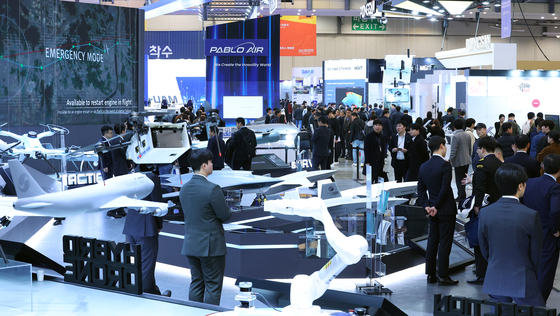 Visitors at the Drone Show Korea 2024 inspect unmanned aerial vehicle models displayed at BEXCO Convention Centre in Busan on Wednesday. [YONHAP]