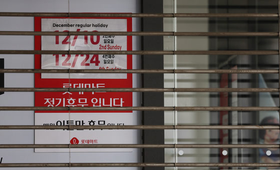 A notice on the Sunday closure schedule is put up at a hypermarket chain in downtown Seoul on Christmas Eve. [YONHAP]