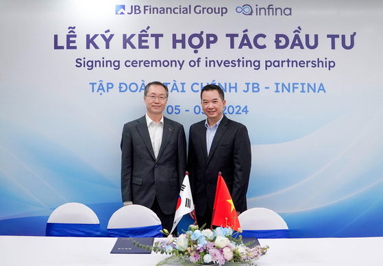 JB Securities Vietnam CEO Kim Doo-yoon, left, and Infina CEO James Vuong pose for a photo during an investment agreement signing ceremony. [JB FINANCIAL GROUP]
