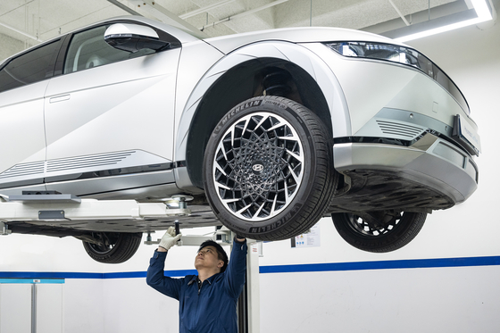 A Hyundai employee inspects a battery on a secondhand Ioniq 5 at the automaker's used car center in Yongin, Gyeonggi. [HYUNDAI MOTOR]