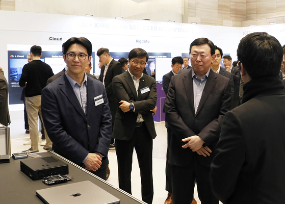 Lotte Chairman Shin Dong-bin, second from right, inspects a booth set up by a local AI startup druing the 2024 Lotte CEO AI Conference held at the Lotte World Tower on Thursday. [LOTTE CORPORATION]