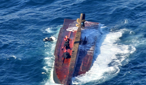 Coast Guard members search a capsized fishing boat on Saturday. A 20-ton vessel was discovered capsized south of Tongyeong, South Gyeongsang, 6:43 a.m. Saturday. [COAST GUARD]