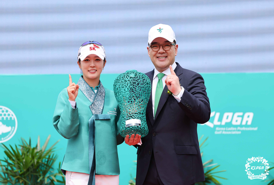 Kim Jae-hee, left, poses with the Hana Financial Group Singapore Women’s Open trophy alongside Hana Financial Group Vice Chairman Lee Eun-hyung after winning the tournament at the Tanah Merah Country Club in Singapore on Sunday. [KLPGA]