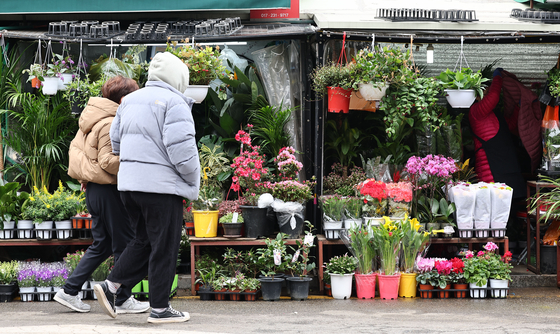 People pass by the flower market situated in Jongno District, central Seoul, on Monday. [YONHAP]