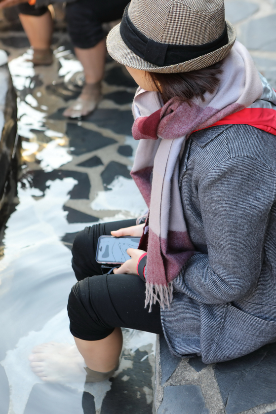 A visitor dry dipping her feet in Deokgu Valley's Wontang [GNC 21] 