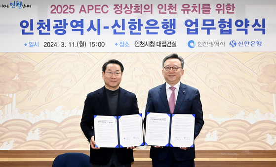 Incheon Mayor Yoo Jeong-bok, left, and Shinhan Bank CEO Jung Sang-hyuk hold signed memorandum of understanding at the Incheon City Hall on Monday. [INCHEON METROPOLITAN CITY] 