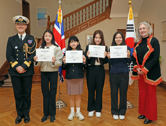 Andy Lamb, British defense attaché in Korea, far left, and his wife, far right, pose for a photo with the winners of the International Women's Day video competition after the award ceremony at the British Embassy in Seoul on Friday. [PARK SANG-MOON]