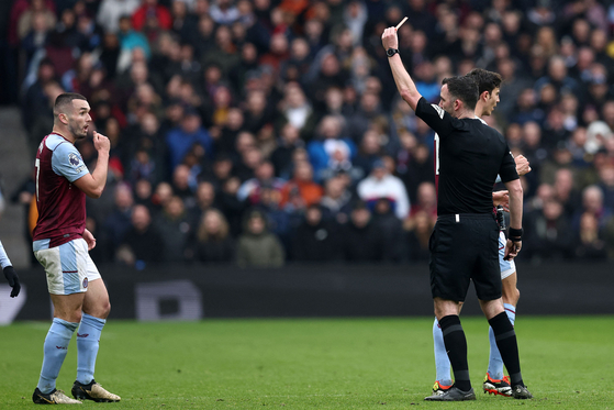 Referee Chris Kavanagh shows a red card to Aston Villa's John McGinn during a Premier League match against Tottenham Hotspur at Villa Park in Birmingham, England on Sunday.  [AFP/YONHAP]