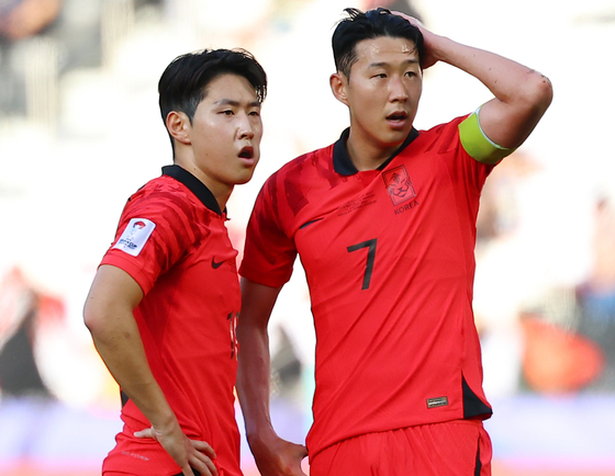 Son Heung-min, right, and Lee Kang-in discuss tactics before taking a free kick during an Asian Cup group stage game against Bahrain in Doha on Jan. 15.  [YONHAP]