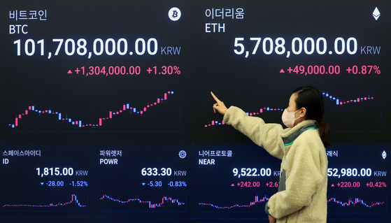 The price of bitcoin is displayed on an electronic board at Upbit Lounge in Gangnam District, southern Seoul, on Tuesday. Bitcoin hit a record high of 101.98 million won ($77,847) that day. [NEWS1]