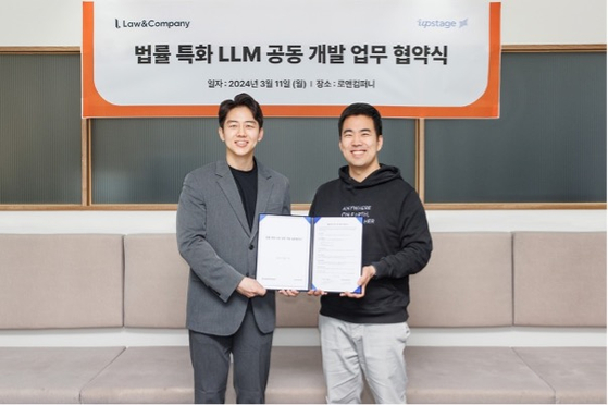 Law&Company Vice Chairman Jung Jae-sung, left, and Upstage Vice President Kwon Soon-il pose for a photo after a signing ceremony at Law&Company's headquarters in Gangnam District, southern Seoul, on Monday. [LAW&COMPANY]
