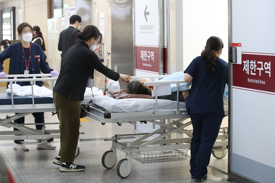 Medical professionals transport a bed and a patient to an emergency room at general hospital in Daegu on Wednesday. [NEWS1] 