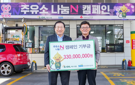 S-Oil President Ahn Jong-bum, right, and Korea National Council on Social Welfare Chairman Kim Sung-i pose for a photo during a donation handover ceremony held in western Seoul on Wednesday. [S-OIL]