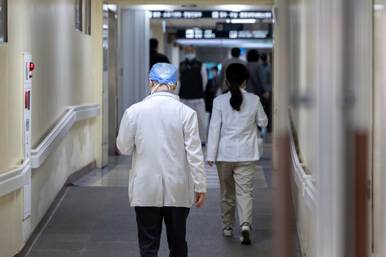 Medical professionals walk in a corridor at a general hospital in Seoul on Wednesday. [YONHAP]  