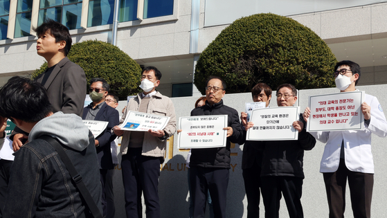 Professors of Jeonbuk National University’s Medical School on Wednesday protest against the medical college admission quota hike before Education Minister Lee Ju-ho’s visit to the campus in North Jeolla on the same day. [YONHAP]