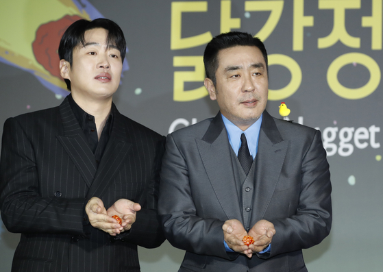 Ahn Jae-hong, left, and Ryu Seung-ryong pose with pieces of dakgangjeong during a press conference for "Chicken Nugget" [NEWS1]