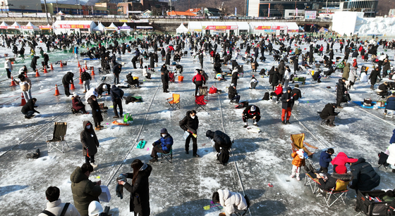 People enjoy ice fishing during the Hwcheon Sancheoneo Ice Festival in Gangwon on Jan. 27. [NEWS1]