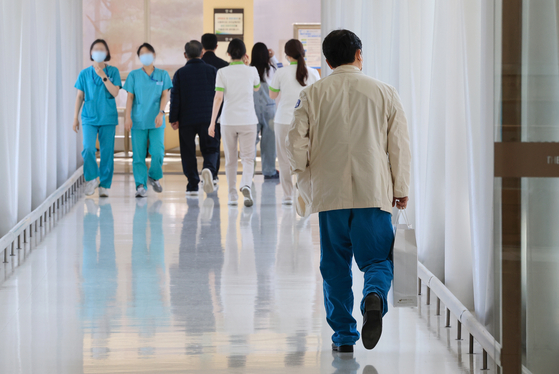 Medical professionals walk inside a general hospital located in Seoul on Thursday, amid a prolonged standoff between doctors and the government. The impasse was caused by a governmental decision to hike admission quota at medical colleges by 2,000 seats starting next year, and medical professors will decide whether to resign en masse Friday. [YONHAP]  