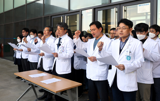 Professors at Jeju National University's medical school call on the government to abandon its plan to increase medical recruitment by 2,000 slots next year on Friday. [YONHAP]