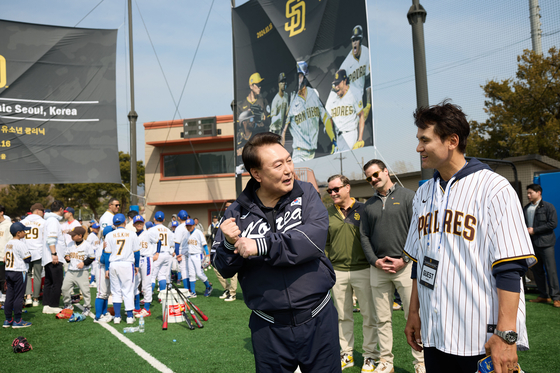 President Yoon Suk Yeol, left, chats with former Los Angeles Dodgers pitcher Park Chan-ho, right, during a youth event at the children's baseball field of the Yongsan Children's Garden in central Seoul on Saturday. [JOINT PRESS CORPS]