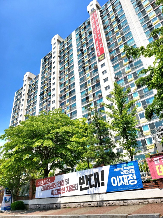 Banners opposing the construction of a data center are hung on balconies at an apartment complex in Hogye-dong, Anyang, in Gyeonggi. [CITY COUNCIL MEMBER KIM DO-HYUN]