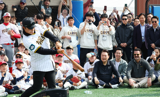 President Yoon Suk Yeol and young players watch a batting demonstration by Kim Ha-seong, left, shortstop for the San Diego Padres, during a youth event at the children's baseball field of the Yongsan Children's Garden in central Seoul on Saturday. [JOINT PRESS CORPS]