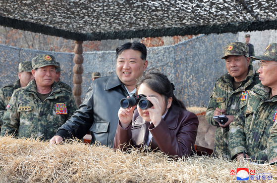 North Korean leader Kim Jong-un, center left, and his daughter, Ju-ae, inspect a military drill of air-borne army units Friday, in a photo carried by its state-run Korean Central News Agency on Saturday. [YONHAP]