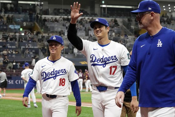 Los Angeles Dodgers' designated hitter Shohei Ohtani, center, and pitcher Yoshinobu Yamamoto, left, walk together at the start of an exhibition game between the Los Angeles Dodgers and Kiwoom Heroes at Gocheok Sky Dome in western Seoul on Sunday.  [AP/YONHAP]