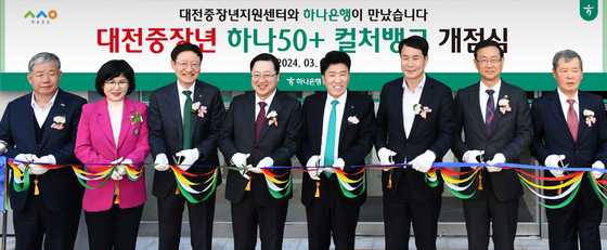 Hana Financial Group Chairman Ham Young-joo, fourth from right, and Daejeon Mayor Lee Jang-Woo, fifth from right, and other officials take a photo at the ribbon-cutting ceremony to celebrate the opening of Hana 50+ Culturebank in Daejeon on Friday. [HANA FINANCIAL GROUP] 