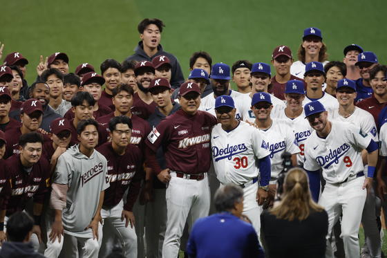 The Kiwoom Heroes, in red, pose with the Los Angeles Dodgers after playing an exhibition game at Gocheok Sky Dome in western Seoul on Sunday.  [NEWS1]