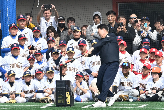 President Yoon Suk Yeol, center, gives a batting demonstration at a youth baseball event held at the children's baseball field in Yongsan Children's Garden in central Seoul on Saturday. Kim Ha-seong, an MLB Gold Glove winner and shortstop for the San Diego Padres, and Park Chan-ho, a former Los Angeles Dodgers pitcher and the first Korean to play in the MLB, attended the event, to which young baseball players were invited. [JOINT PRESS CORPS] 