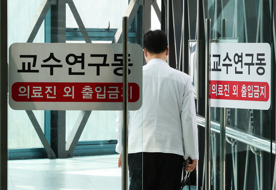 A doctor enters a professors' lab at a hospital in Seoul on Sunday. Professors at medical schools decided to submit resgination letters starting March 25 in solidarity with junior doctors who have been on a monthlong strike to protest the government's decision to increase the medical school enrollment quota by 2,000 starting next year. [YONHAP] 
