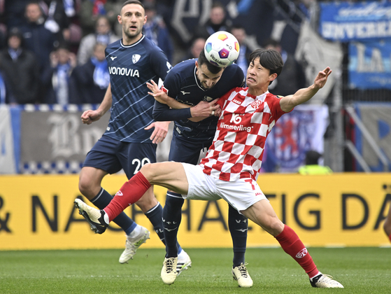 Mainz's Lee Jae-sung Lee, right, vies for the ball with VfL Bochum's Anthony Losilla during a 2023-24 Bundesliga match at Mewa Arena in Mainz, Germany on Saturday. [AP/YONHAP]