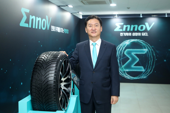 Kumho Tire CEO Jung Il-taik poses for a photo with its EV-dedicated EnnoV tire. [KUMHO TIRE]