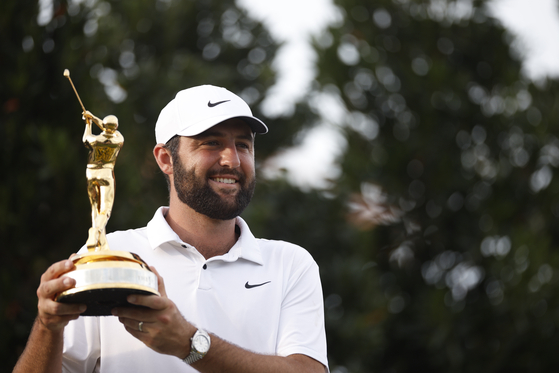 Scottie Scheffler poses with the Players Championship trophy after putting in to win on the 18th hole for his second consecutive win at The Players Championship during the final round at the Stadium Course at TPC Sawgrass in Ponte Vedra Beach, Florida on Sunday. [GETTY IMAGES]