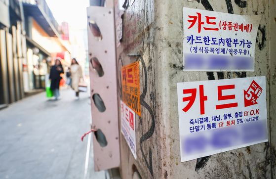 Advertisements for card loans are adhered to a wall on a street in Myeong-dong, central Seoul, on Sunday. [YONHAP] 