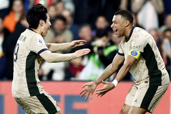 Paris Saint-Germain's Lee Kang-in celebrates scoring the team's fourth goal with Kylian Mbappe at Stade de la Mosson in Montpellier, France on Sunday. [REUTERS/YONHAP]