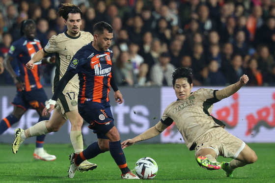 Montpellier's Teji Savanier, third from left, fights for the ball with Paris Saint-Germain's Lee Kang-in during the match at Stade de la Mosson in Montpellier, France on Sunday. [AFP/YONHAP]