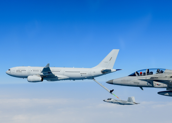 A KF-21 fighter jet, center, flies while connected to a KC-330 tanker aircraft during an aerial refueling test off the southeastern coast of Korea on Tuesday. [NEWS1]