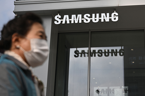 A woman walks past the Samsung logo in front of a Samsung Electronics store in Seoul on October 31, 2023. [AFP/YONHAP]