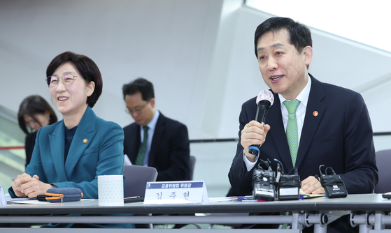 Financial Services Commission Chairman Kim Joo-hyun, right, speaks during a press conference held on Tuesday in western Seoul. To his left is Environment Minister Han Wha-jin. [NEWS1] 