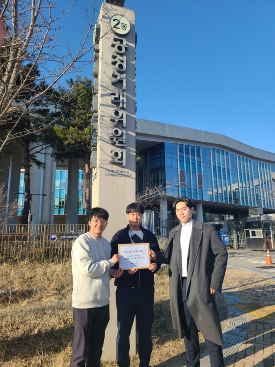 Attorney and Korea Game User Association (KGUA) Chair Lee Cheol-woo, far right, and gamers pose for the photo on Monday in front of the Fair Trade Commisison's office in Sejong. [KGUA]